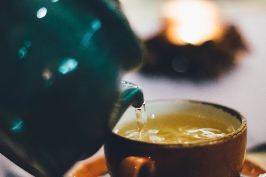 Teapot pouring green tea
